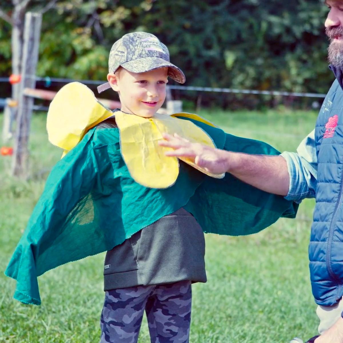 A young boy dresses up as a pea plant.