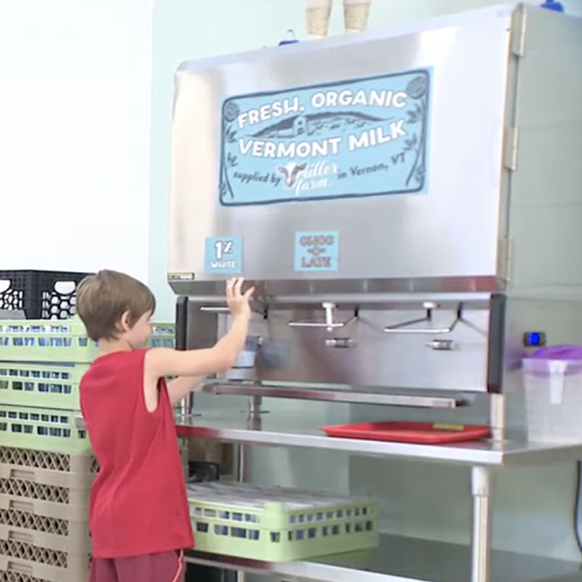 Student pours milk from a cafeteria bulk container Student pours milk from a cafeteria bulk container