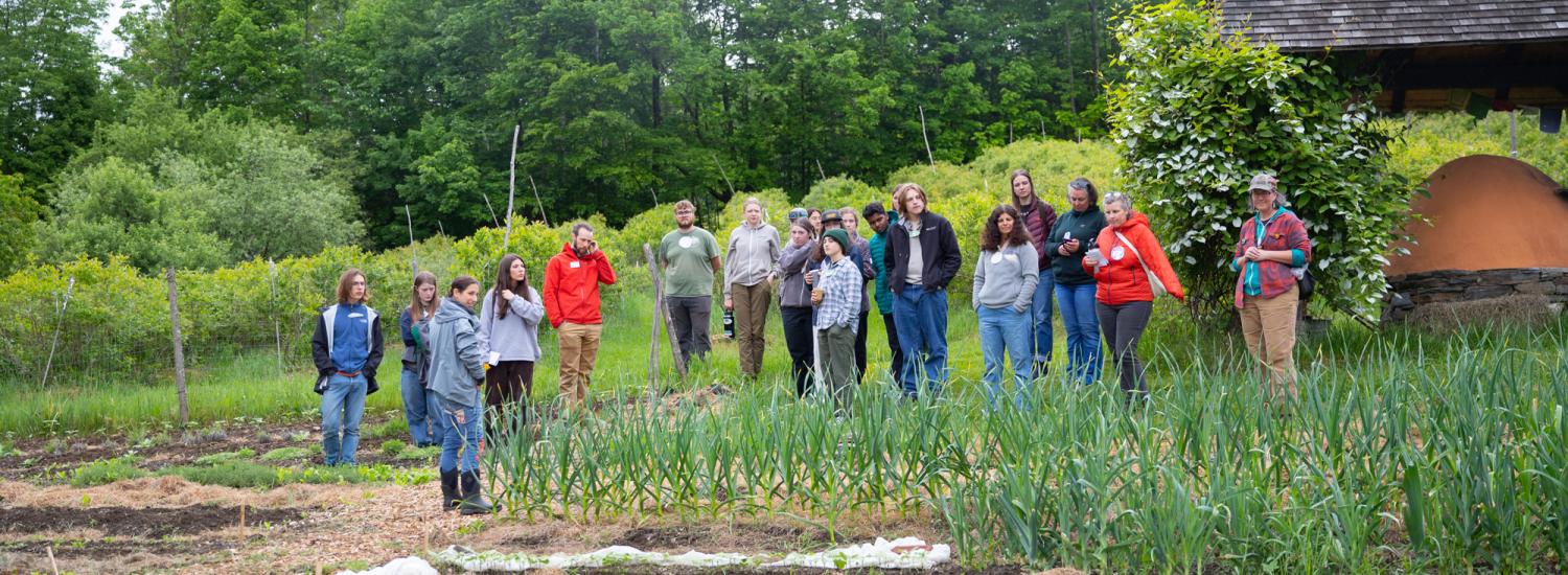 Students and educators gather near a garden